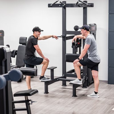 Zwei Männer im Beratungsgespräch an einer Trainingsstation